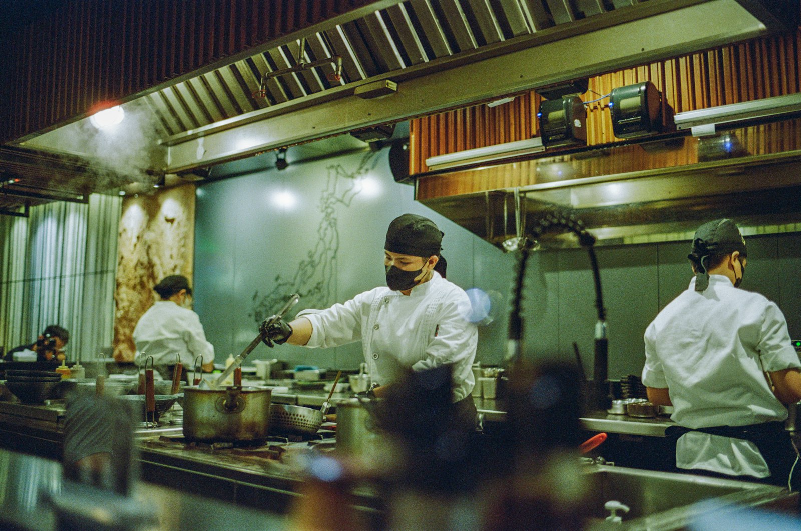 Brigade de cuisine au travail dans un restaurant, représentant les métiers de l'hôtellerie et de la gastronomie